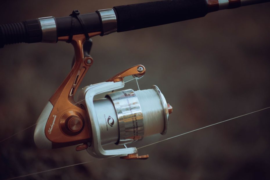 Detailed view of a fishing reel with line tension, showcasing precise fishing equipment mechanics.